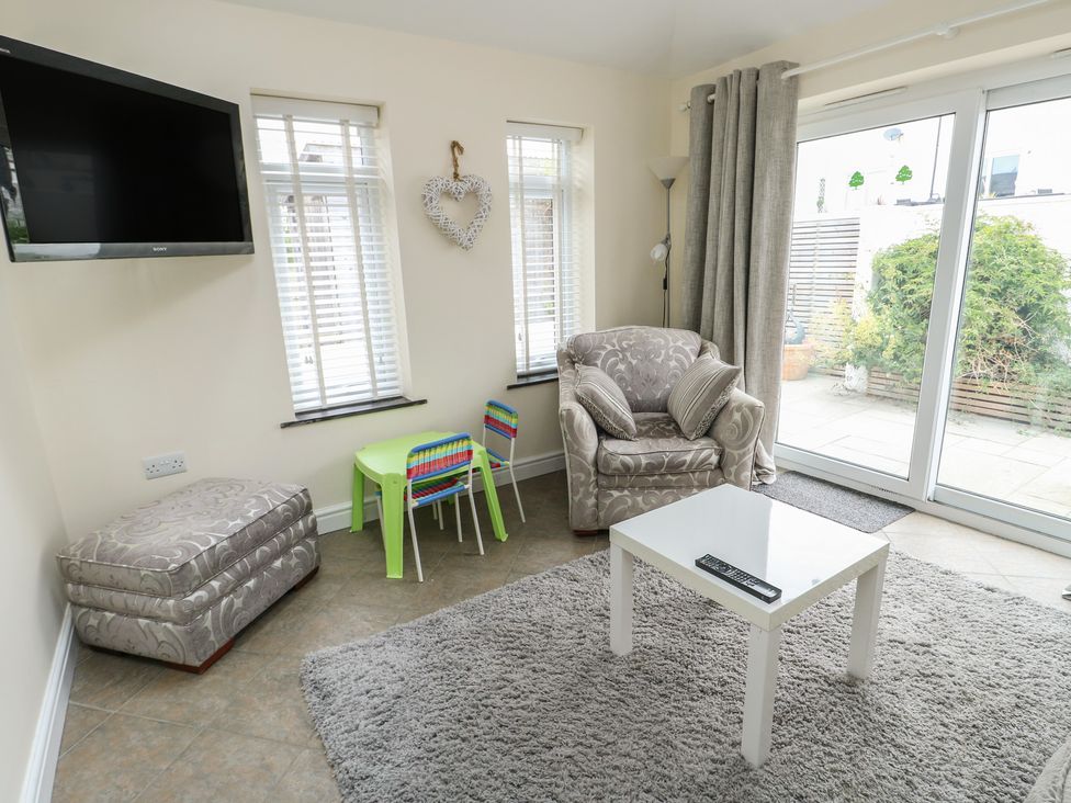 A living room with a television and seating area at Ty Haf in Trearddur Bay