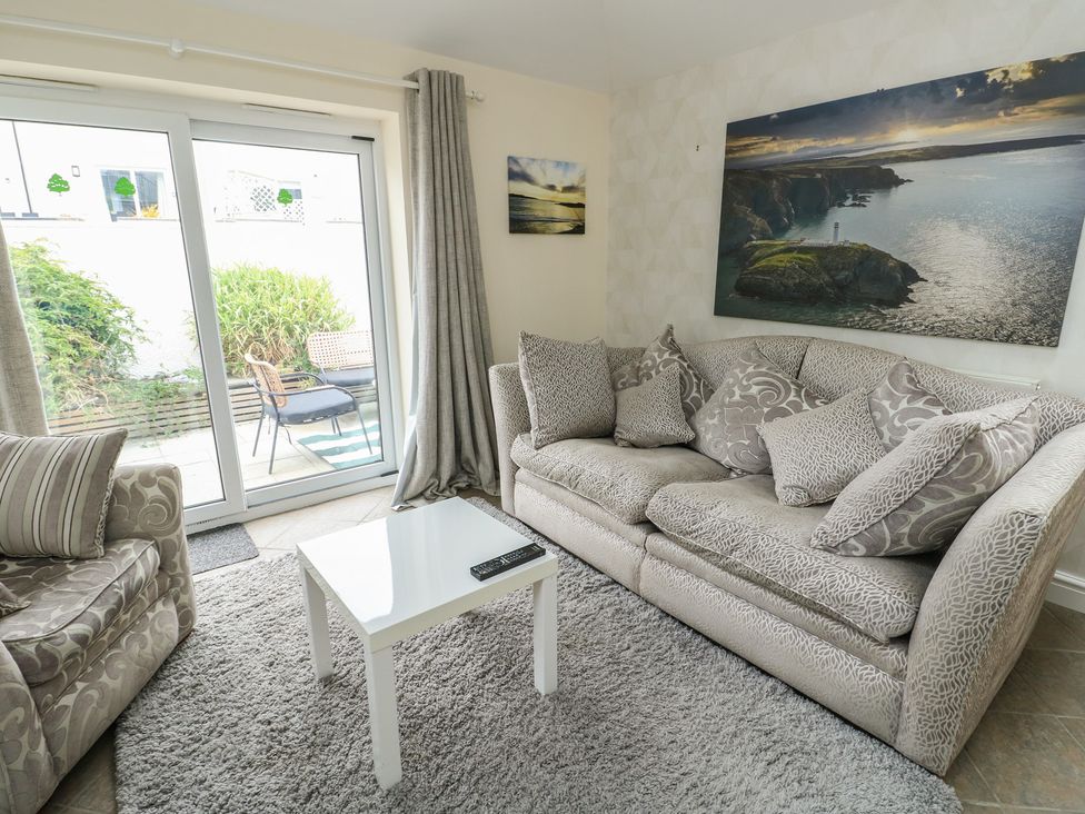 A living room with a sofa and coffee table at Ty Haf in Trearddur Bay