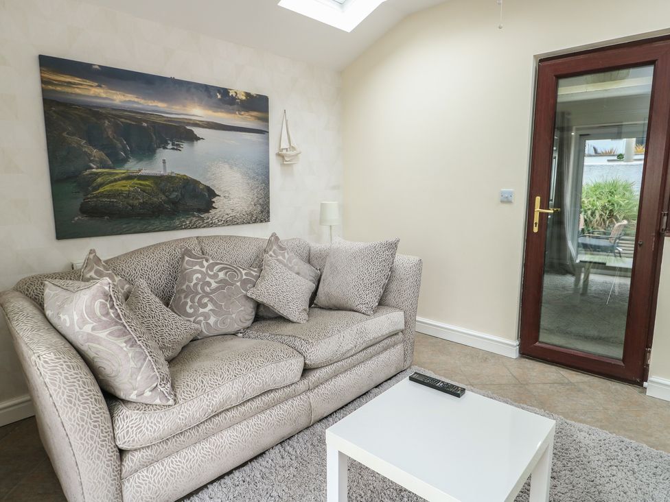 A living room with a sofa and coffee table at Ty Haf in Trearddur Bay