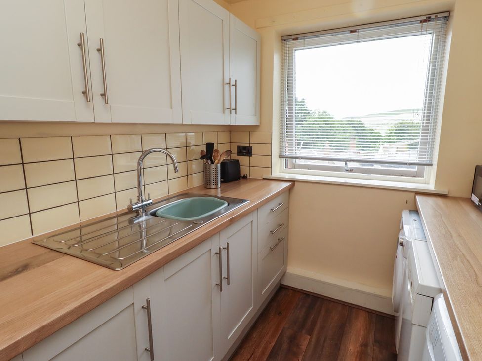 A kitchen with a sink and kitchen cabinets at Flodden Apartment in Wooler