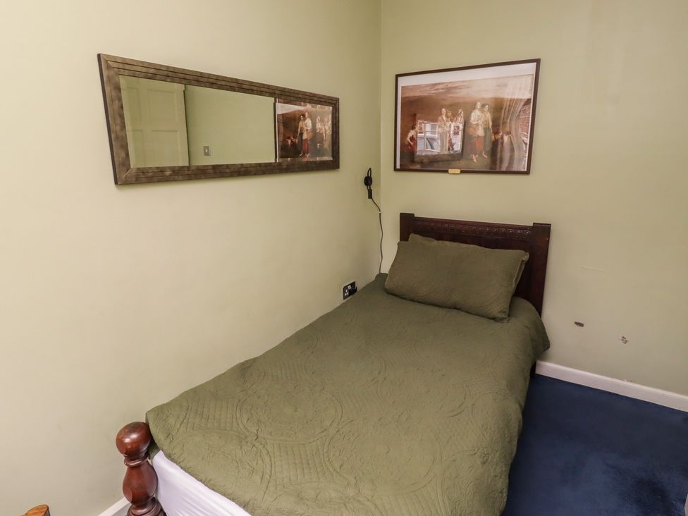 A bedroom with a bed and mirror at Flodden Apartment in Wooler