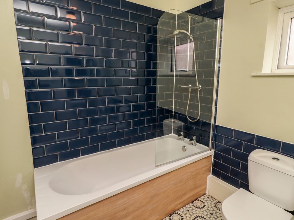 A bathroom with a bathtub and toilet at Flodden Apartment in Wooler