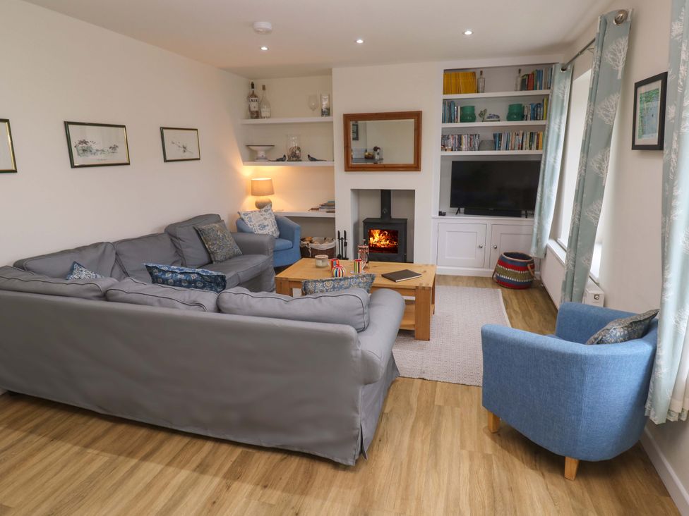 A living room with a sofa and armchair at Fair View in St Just in Roseland near St Mawes
