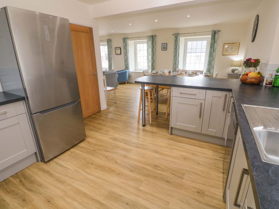 A kitchen with a refrigerator and wooden table at Fair View in St Just in Roseland near St Mawes