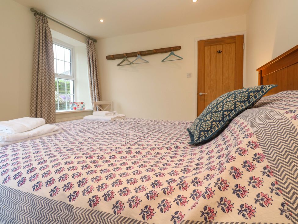 A bedroom with a bed and curtains at Fair View in St Just in Roseland near St Mawes