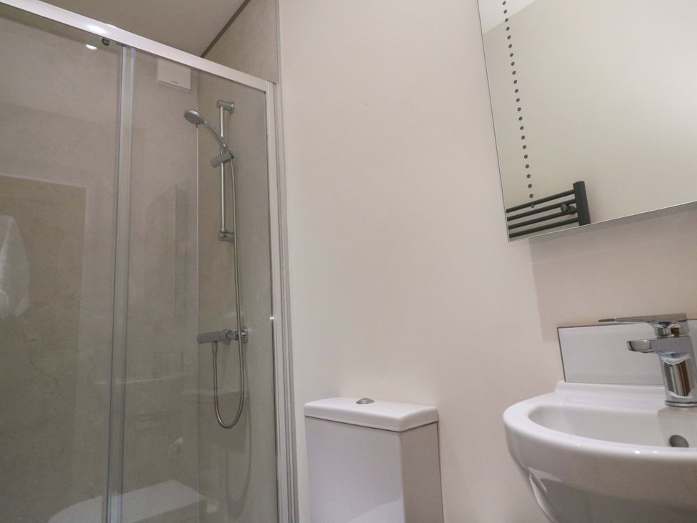 A bathroom with a shower, toilet, and sink at Fair View, St Just in Roseland near St Mawes
