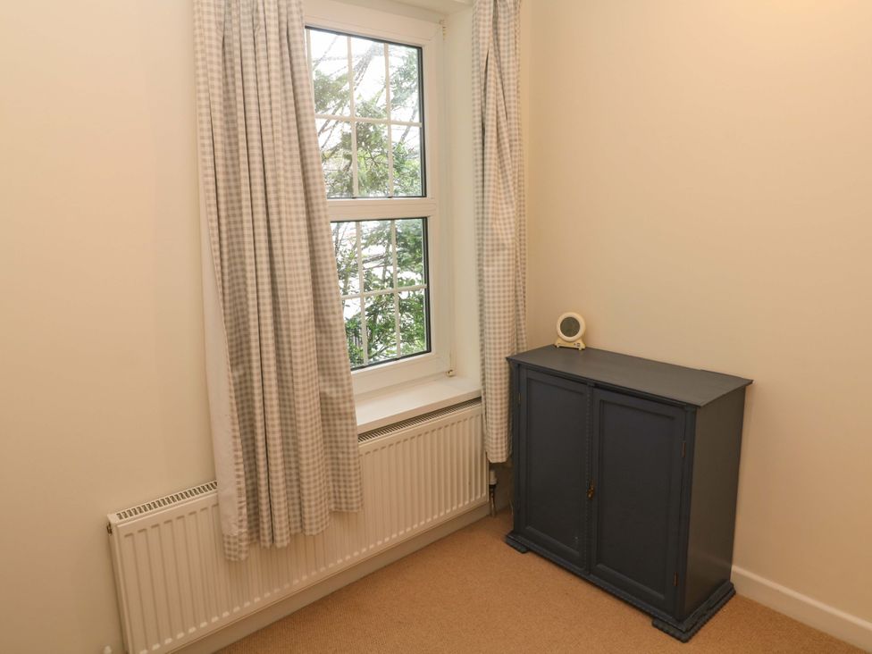 A bedroom with a window and a cabinet at Fair View St Just in Roseland near St Mawes