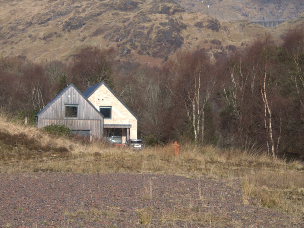 A house surrounded by trees and grass at Taigh Creag Thulach in Taynuilt