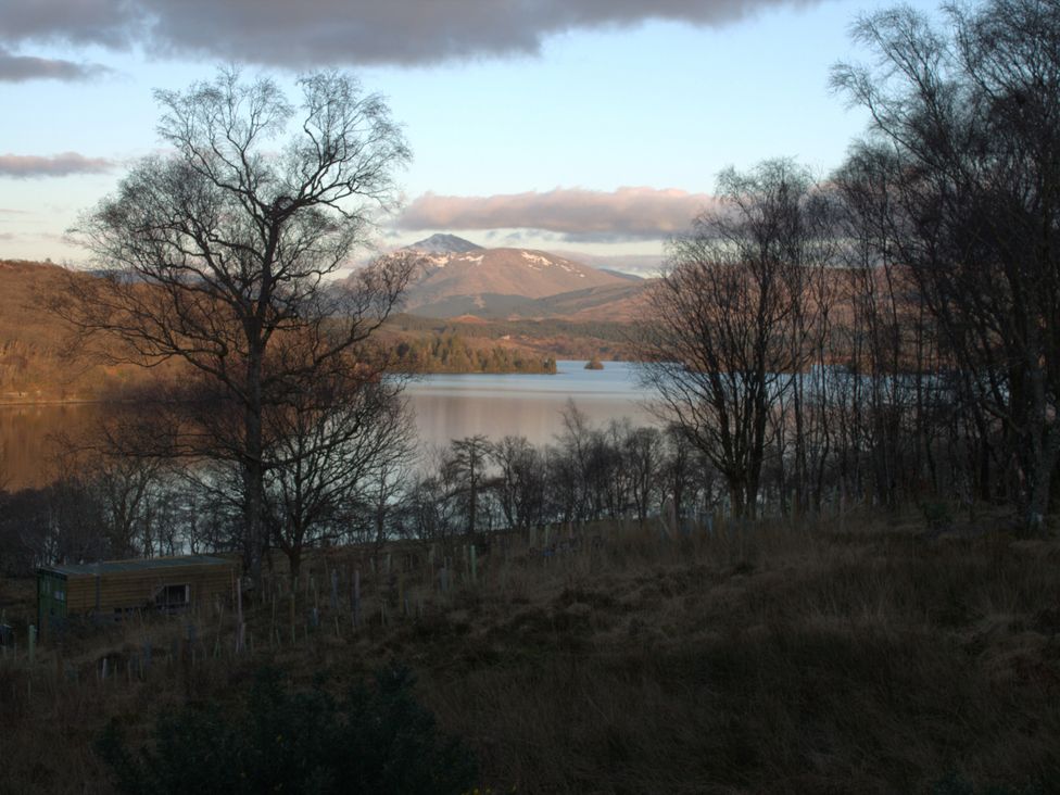 A landscape view featuring a lake, mountains, and trees at Taigh Creag Thulach in Taynuilt