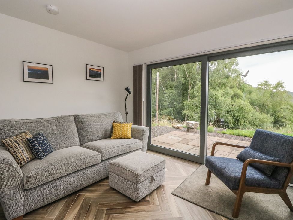 A living room with a sofa and an armchair at Taigh Creag Thulach, Taynuilt