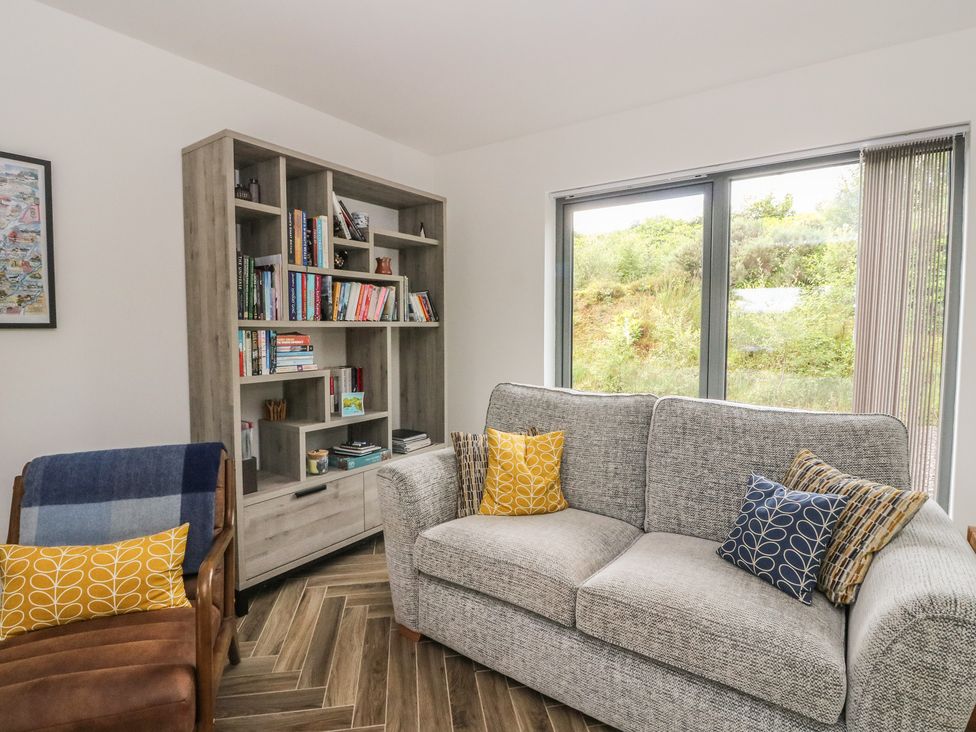 A living room with shelves full of books and a couch at Taigh Creag Thulach in Taynuilt