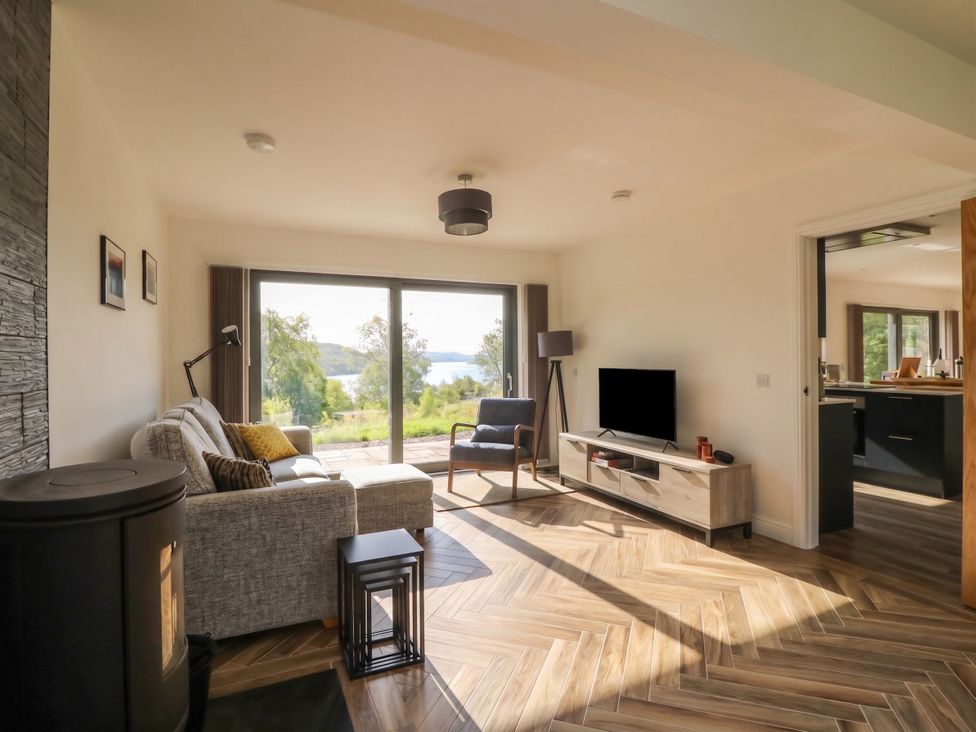 A living room with a sofa and TV at Taigh Creag Thulach Taynuilt