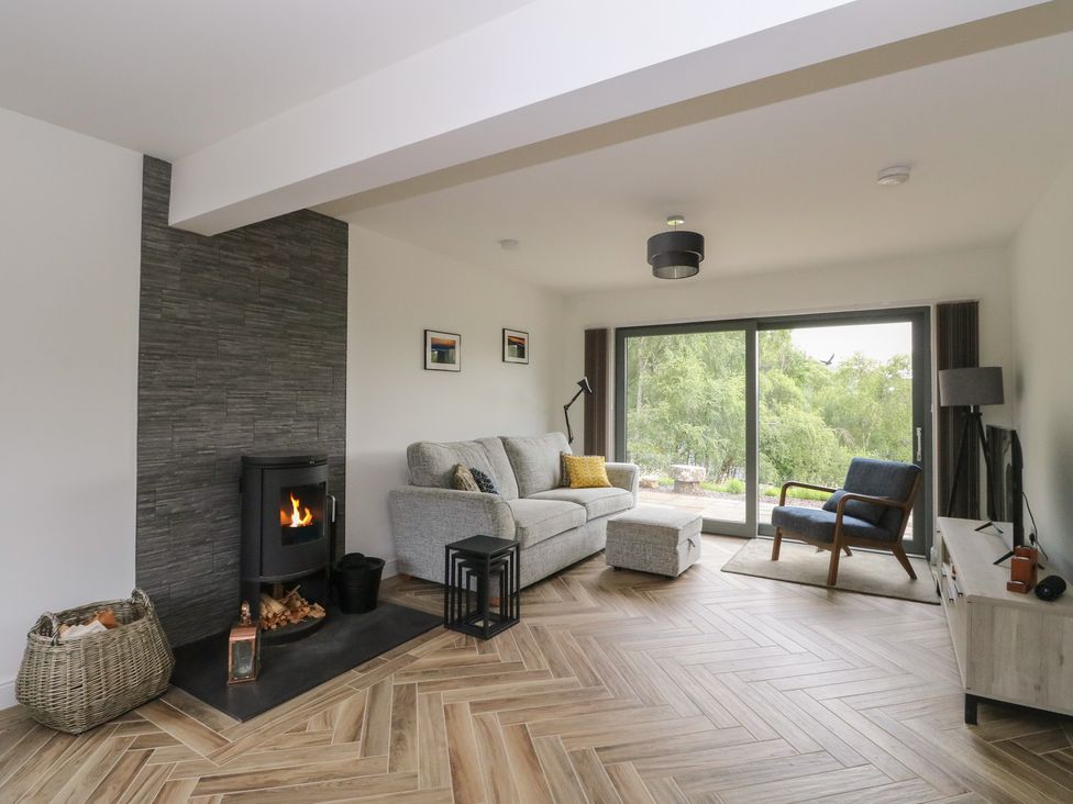 A living room with a fireplace and sofa at Taigh Creag Thulach in Taynuilt