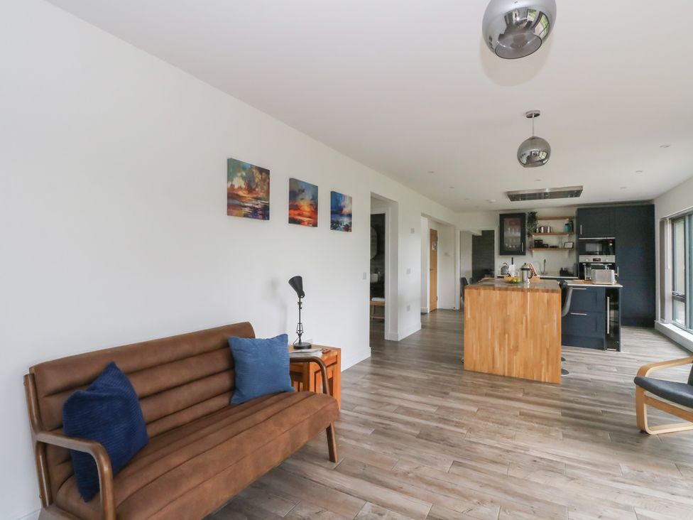 A living room with a sofa and kitchen island at Taigh Creag Thulach in Taynuilt