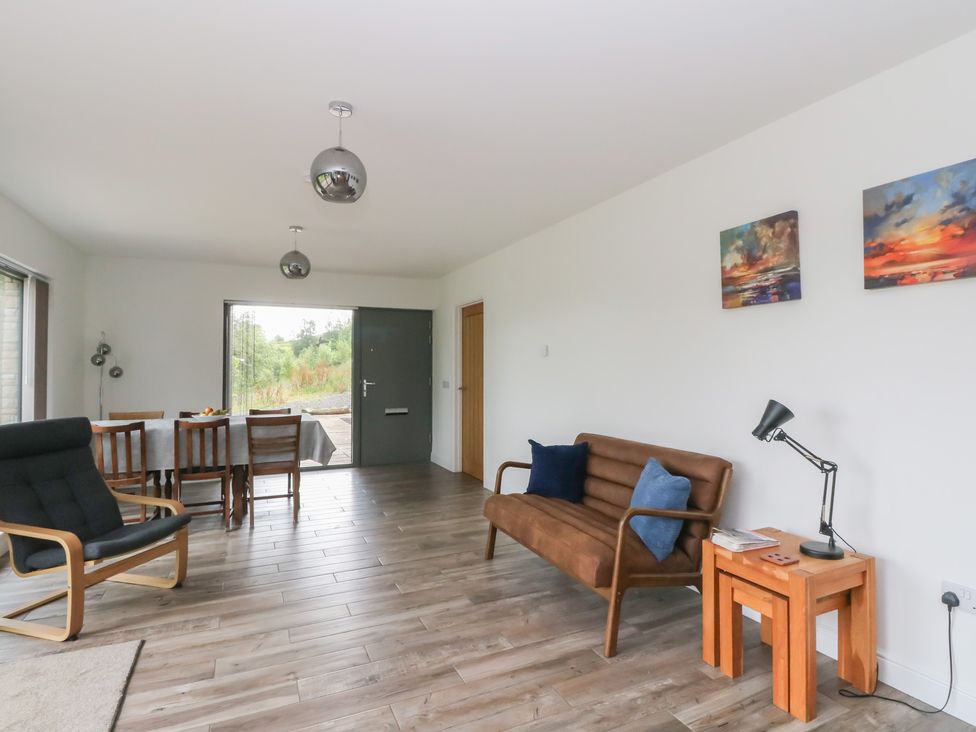 A living room with a sofa and dining table at Taigh Creag Thulach in Taynuilt