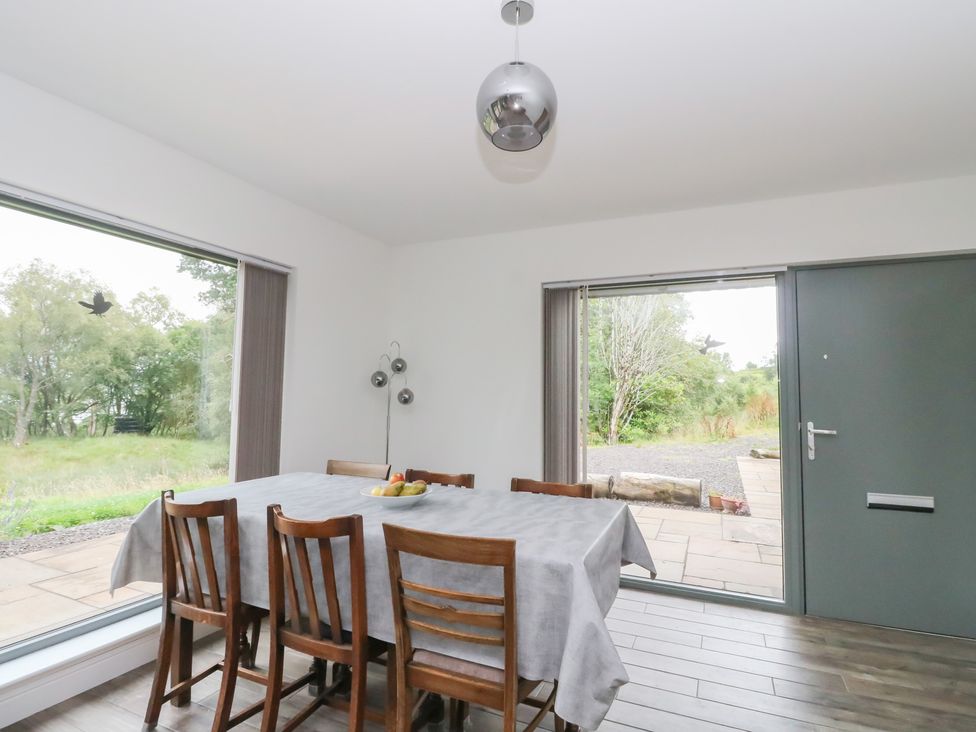 A dining room with a table and chairs at Taigh Creag Thulach Taynuilt
