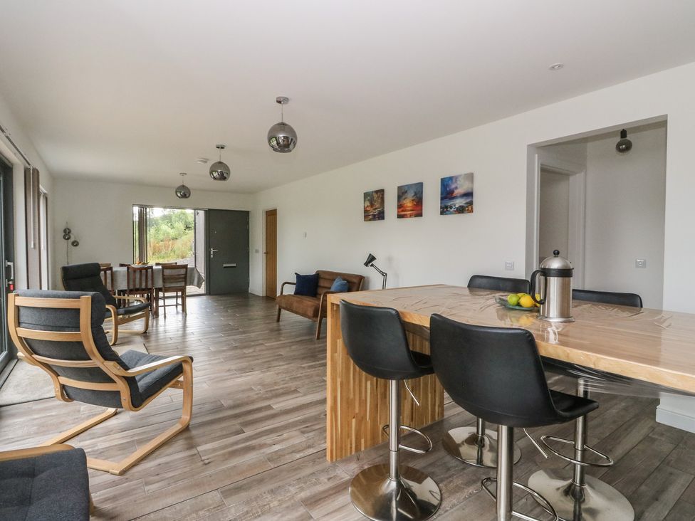 A living room with chairs, a table and a view at Taigh Creag Thulach in Taynuilt