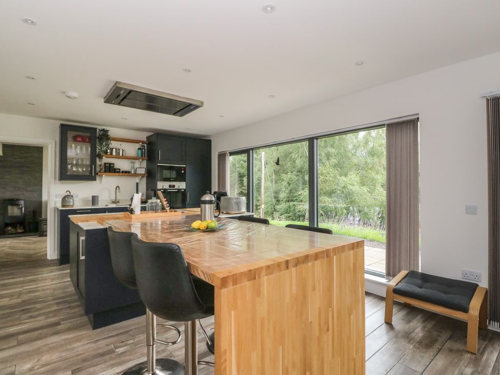 A kitchen with an island and stools at Taigh Creag Thulach in Taynuilt