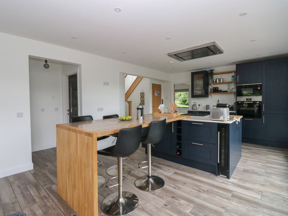 A kitchen with an island and bar stools at Taigh Creag Thulach in Taynuilt