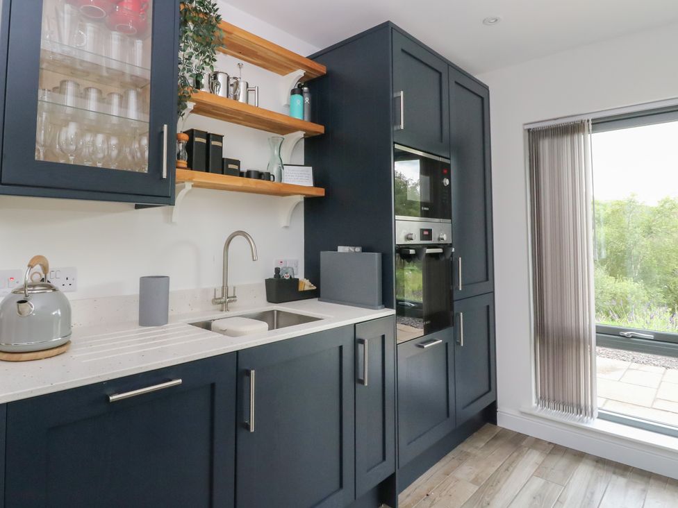 A kitchen with a sink, cabinets, and appliances at Taigh Creag Thulach Taynuilt