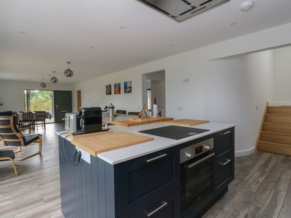 A kitchen with an island and dining area at Taigh Creag Thulach in Taynuilt