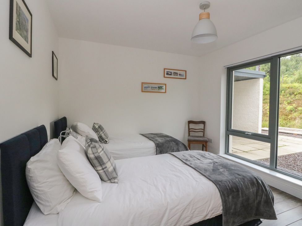 A bedroom with two beds and a window at Taigh Creag Thulach in Taynuilt