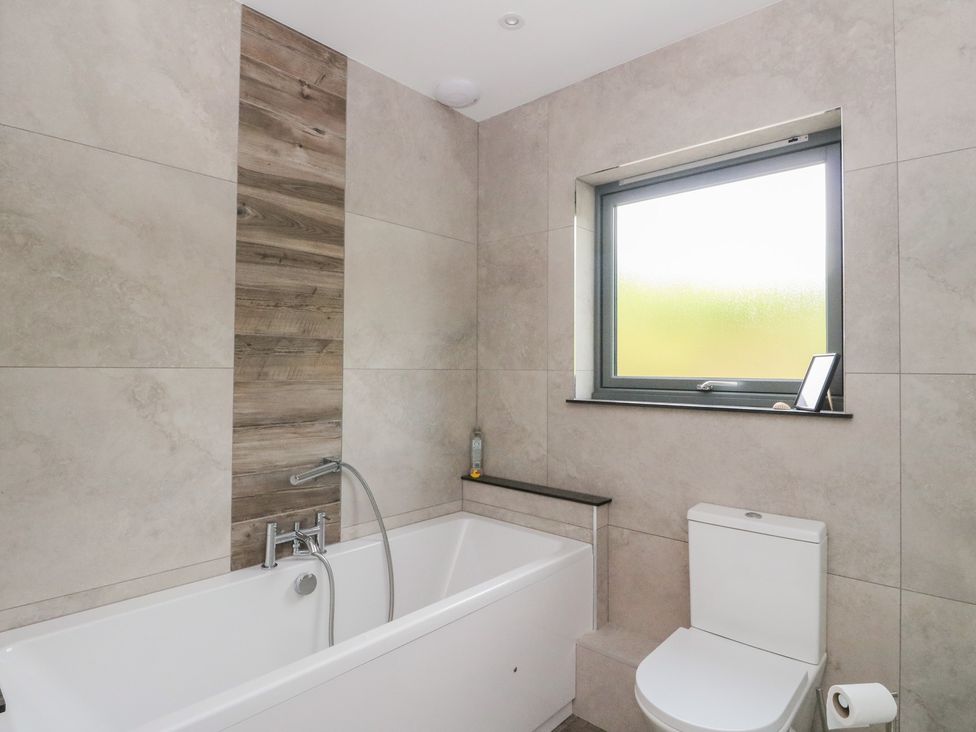A bathroom with a bathtub and toilet at Taigh Creag Thulach Taynuilt