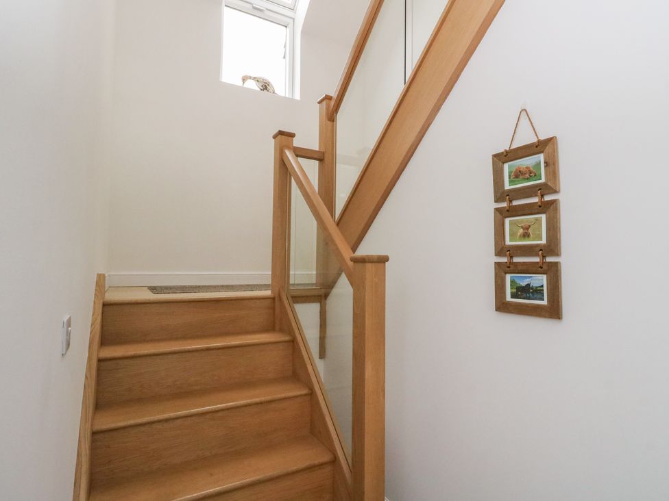A staircase with wooden steps and artwork on the wall at Taigh Creag Thulach in Taynuilt