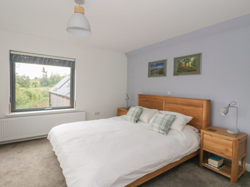 A bedroom with a bed and two paintings at Taigh Creag Thulach in Taynuilt