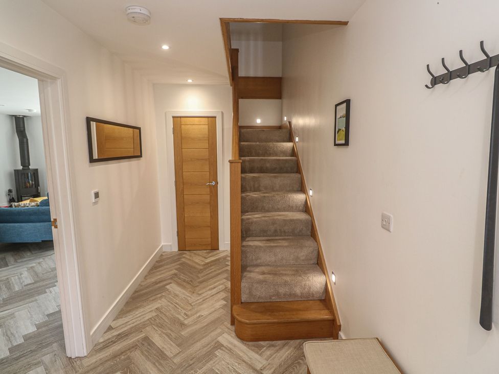A hallway with staircase and door at Carnon Gwel, Devoran
