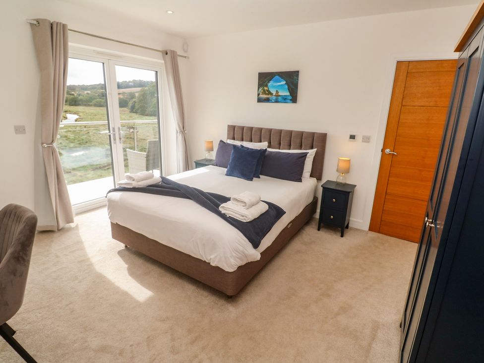 A bedroom with a bed and bedside table at Carnon Gwel, Devoran