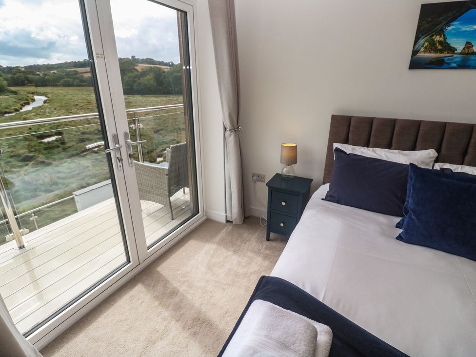A bedroom with a bed and a sliding door at Carnon Gwel, Devoran