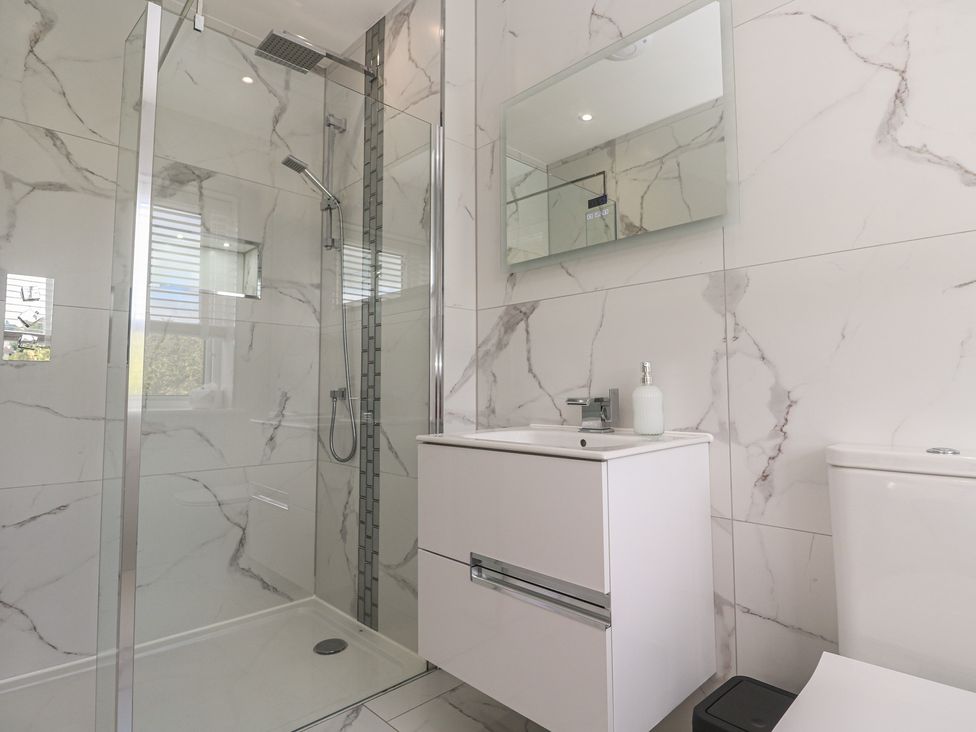 A bathroom featuring a shower, toilet, and sink at Carnon Gwel, Devoran