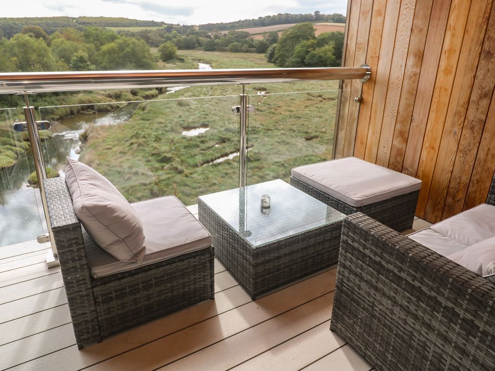 A balcony with seating area and a view of the river at Carnon Gwel, Devoran
