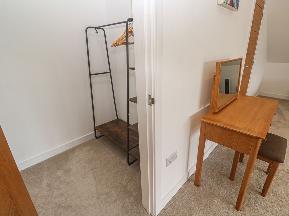 A dressing room with a wardrobe and desk at Carnon Gwel, Devoran