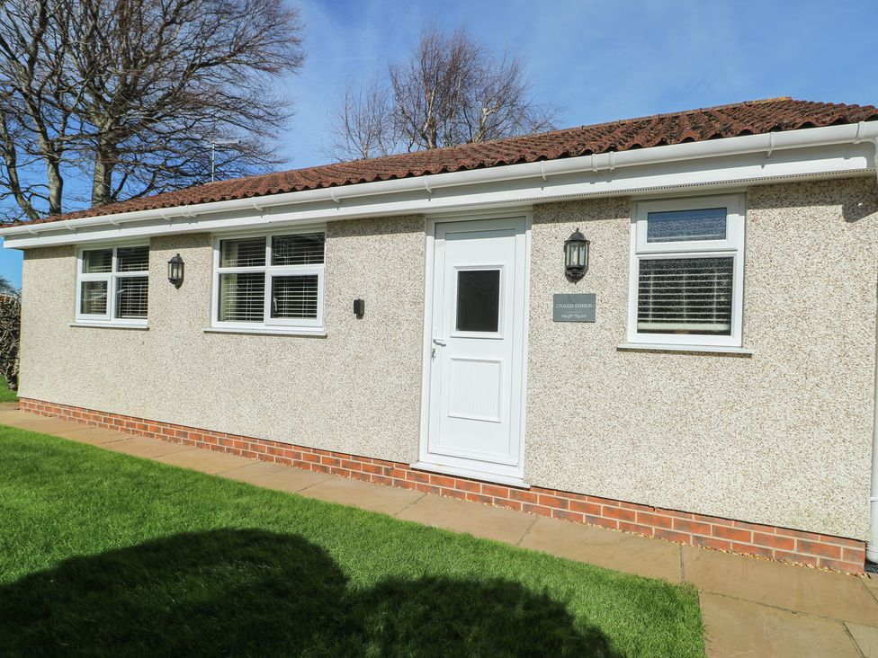 A house exterior with a door, windows, and grass at Trillo Lodge Colwyn Bay