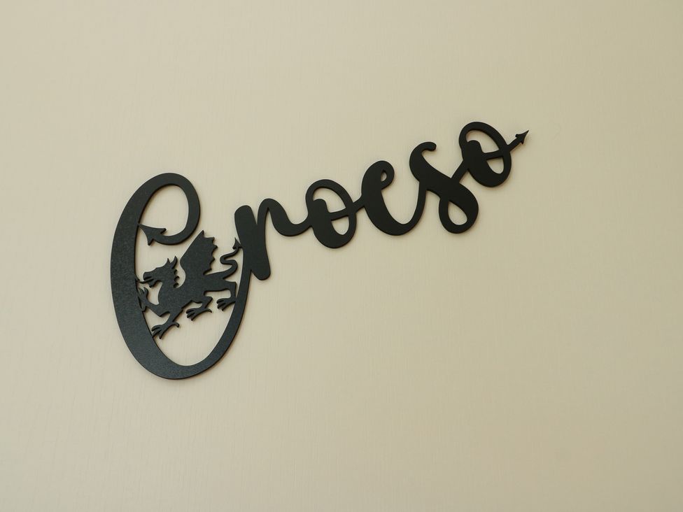 A wall sign featuring a dragon and the word 'proeso' at Trillo Lodge in Colwyn Bay