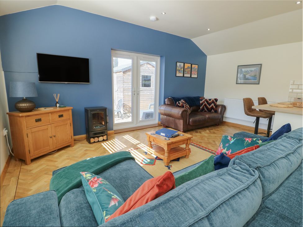 A living room with a television and sofa at Trillo Lodge in Colwyn Bay