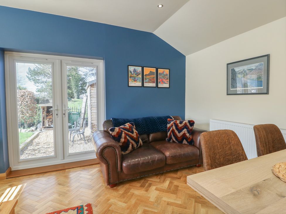 A living room with a sofa and dining table at Trillo Lodge in Colwyn Bay