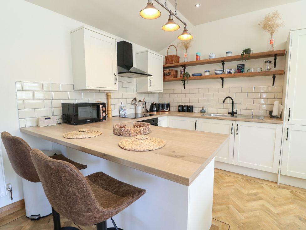 A kitchen with cabinets and shelves at Trillo Lodge in Colwyn Bay