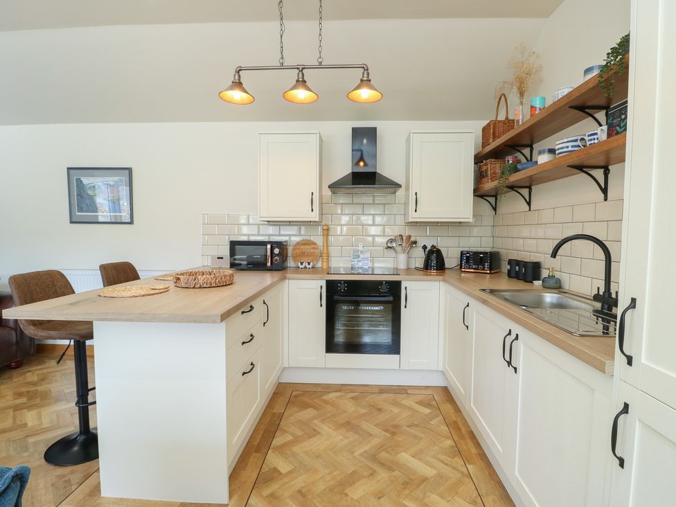 A kitchen with cabinets and appliances at Trillo Lodge in Colwyn Bay