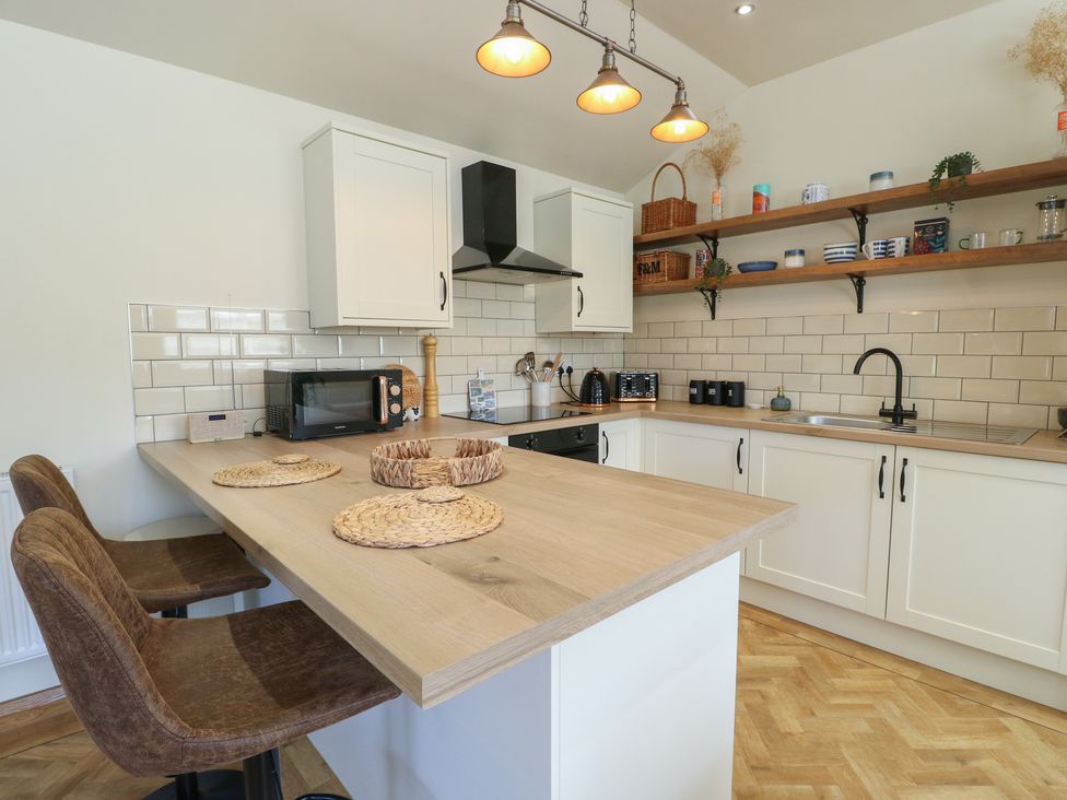A kitchen with bar stools and countertop at Trillo Lodge in Colwyn Bay
