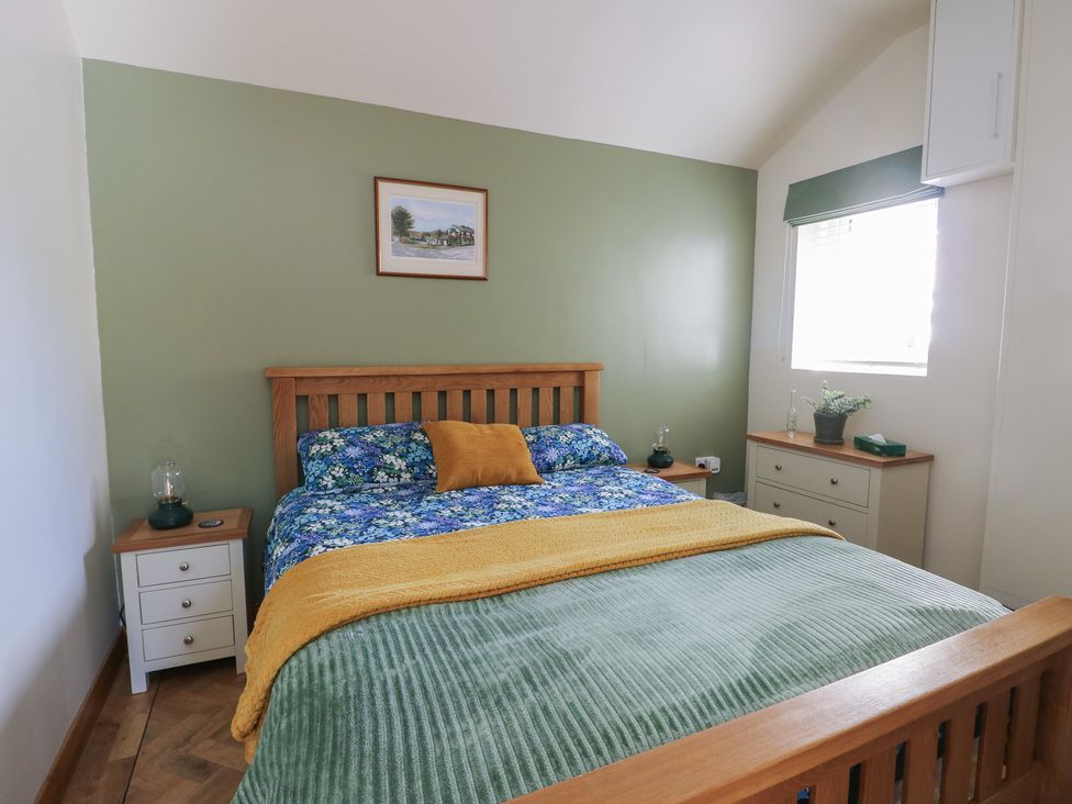 A bedroom with a bed and bedside table at Trillo Lodge in Colwyn Bay