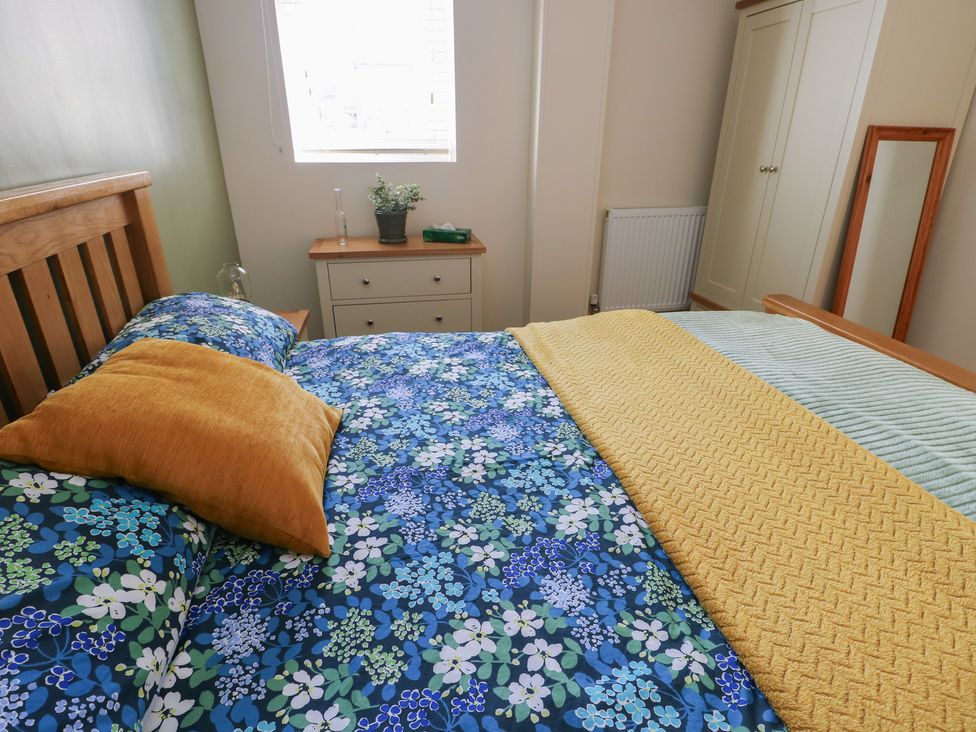 A bedroom with a bed and dresser at Trillo Lodge in Colwyn Bay