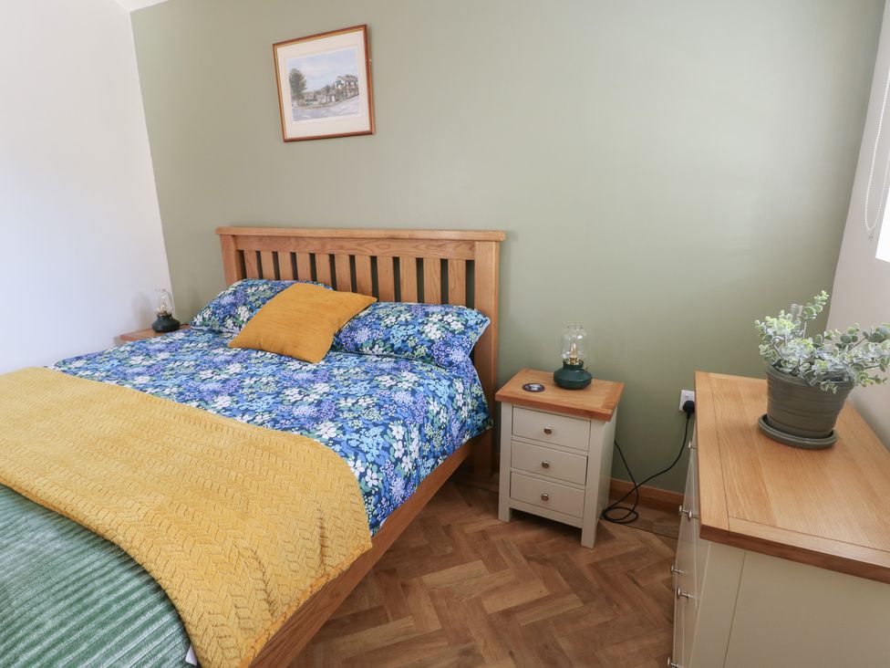 A bedroom with a bed and bedside table at Trillo Lodge in Colwyn Bay