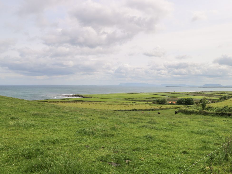 A landscape view of fields and ocean at Doonalton House in Dromore West, County Sligo