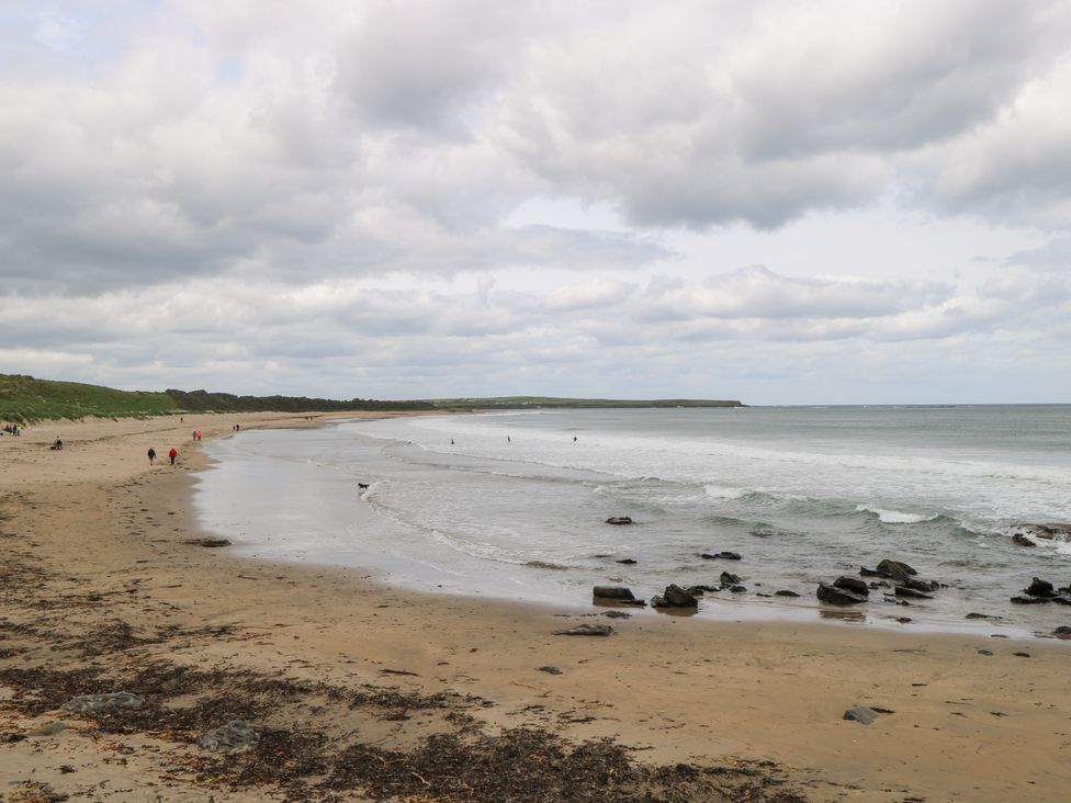 A beach view with people walking along the shore at Doonalton House Dromore West County Sligo