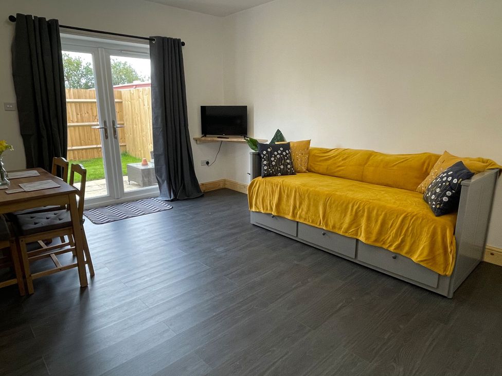 A living room with a sofa and television at Daisy in Hannington near Northampton