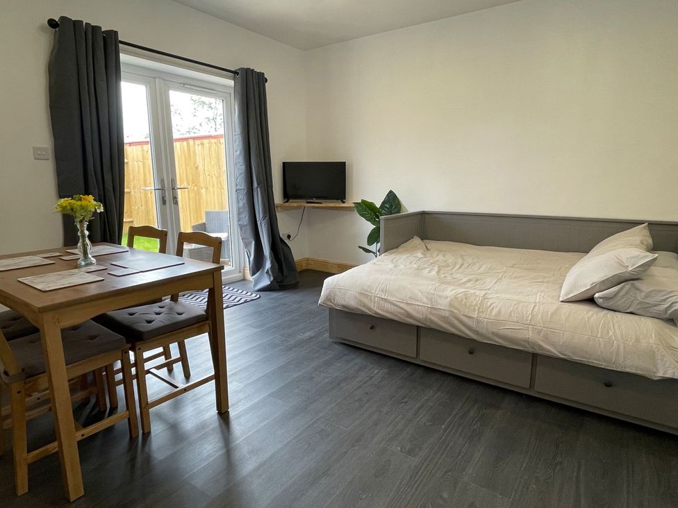A living room with a bed and dining table at Daisy in Hannington near Northampton