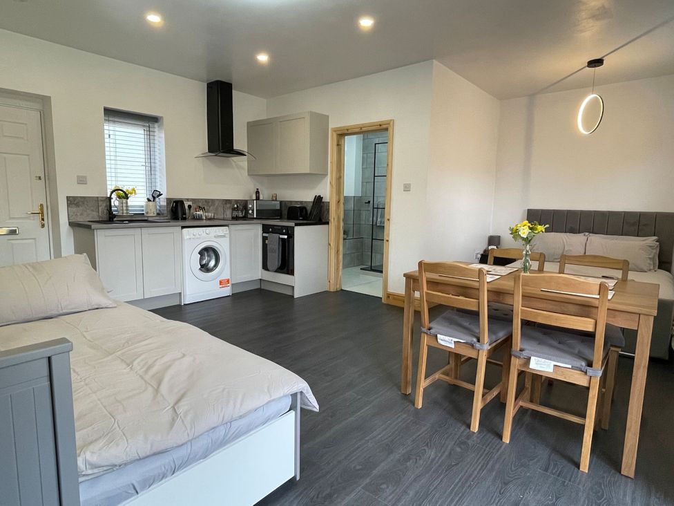 A studio apartment with a kitchenette and dining area at Daisy in Hannington near Northampton